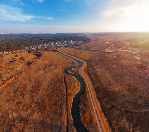 Winding river in field with dry grass