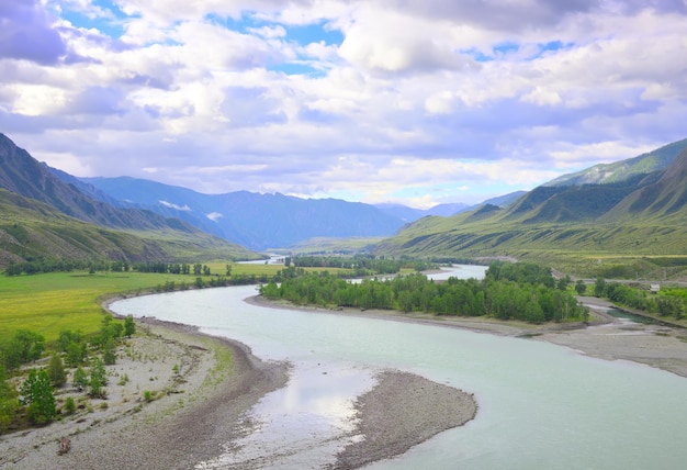 푸른 흐린 하늘 아래 산으로 둘러싸인 구불구불한 강바닥 시베리아 러시아