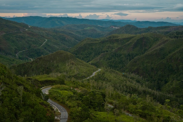 A winding road in the mountains with mountains in the background