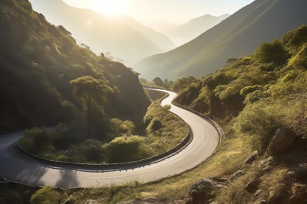 A winding road in the mountains with the sun shining on the horizon.