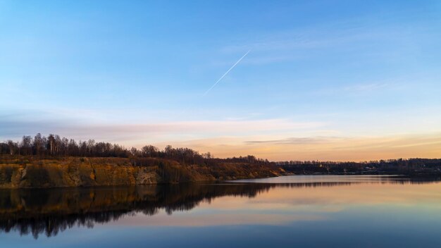 The windless surface of the lake and the reflection of clouds on calm water Leningrad region