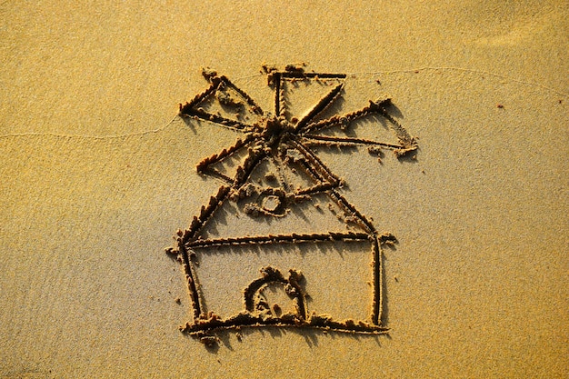 Photo windmill drawn on the beach sand