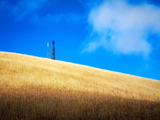 Photo windmill on field against blue sky