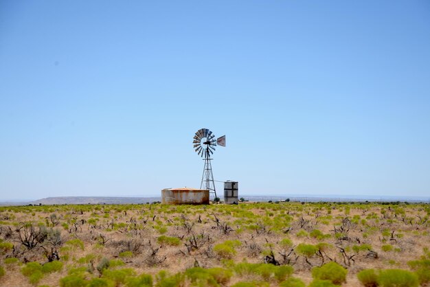 Windmill on field against clear sky