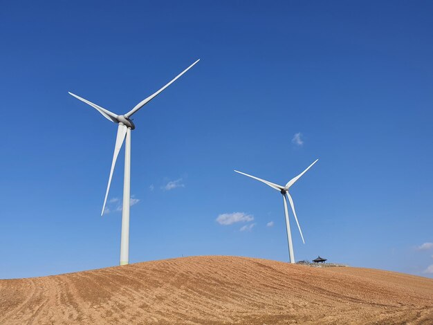 Windmill on field against clear sky