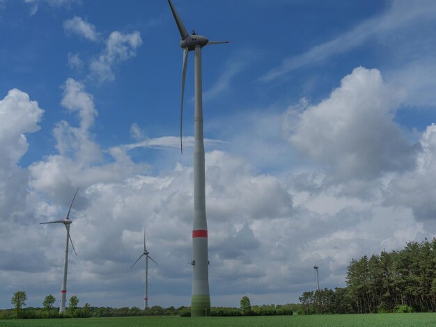 Windmills on field against sky