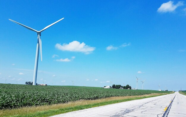 Windmills on field against sky