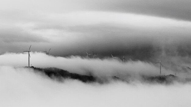 Foto mulini a vento sulla montagna in mezzo alle nuvole