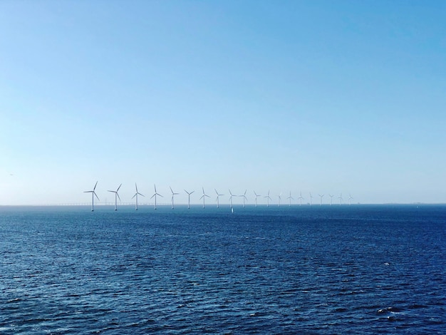 Foto windmolens in de zee tegen een heldere blauwe hemel