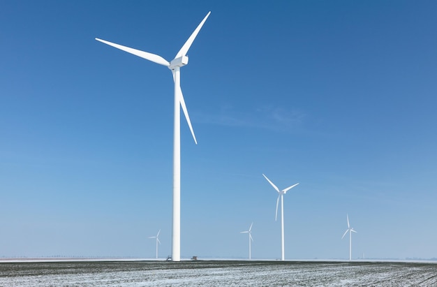 Windmolens in het landschap tegen een heldere blauwe lucht