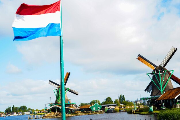 Foto windmolens in zaanse schans en nederlandse vlag