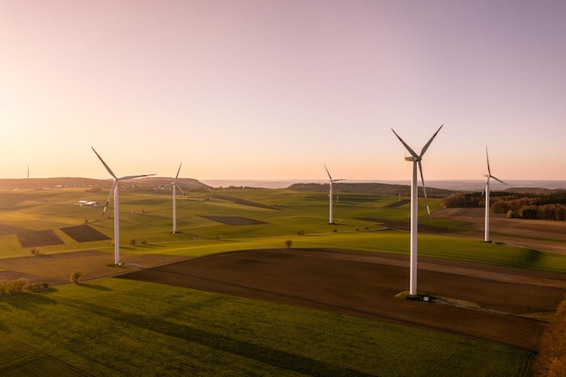 Windmolens op boerderijen tegen de hemel bij zonsondergang