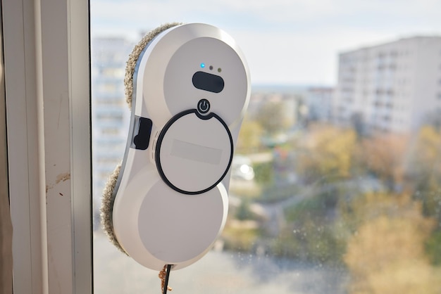 A window cleaner robot washes glass against the backdrop of multistorey buildings