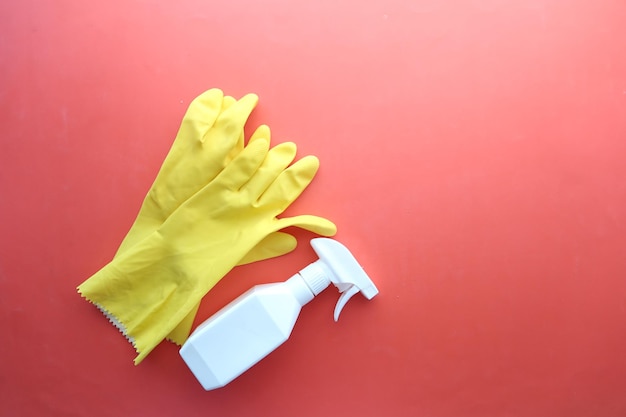 Window cleaning spray brush and gloves on purple background