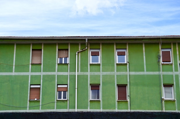 window on the green facade of the house in the city 