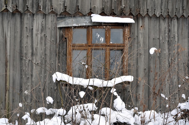 Фото Окно в стене старого деревянного дома. фрагмент старинного,