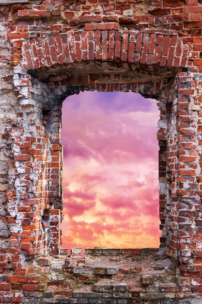 Window into a brick wall overlooking the sunset sky. High quality photo