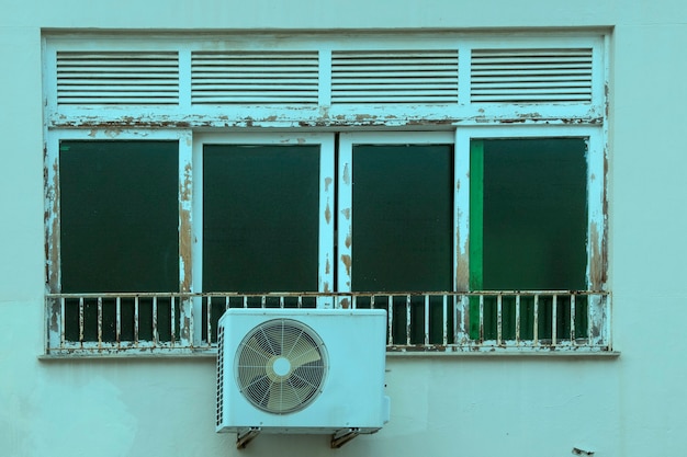 브라질의 건물 외관에 날씨로 인해 페인트칠 된 나무로 된 창문이 악화되었습니다.
