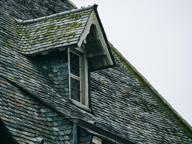 Window protruding between roof tiles, medieval house roofs