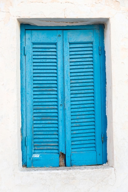 닫힌된 파란색 셔터가 있는 창 그리스