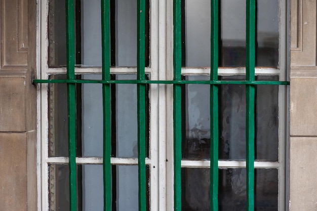 A window with a green bars that say'the door to the left '