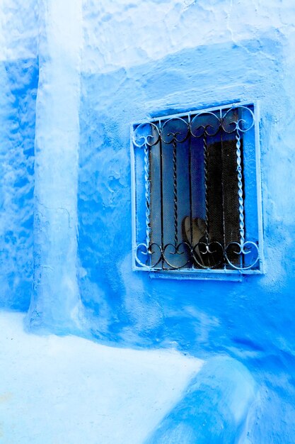 Window with metal on blue wall