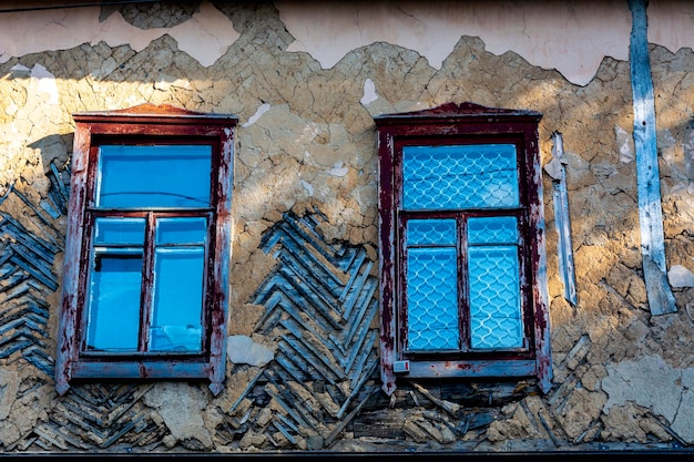 Windows of an old vintage wooden house in the afternoon on a sunny day. Architecture of the provincial city of Ukraine. Soviet Union age building USSR