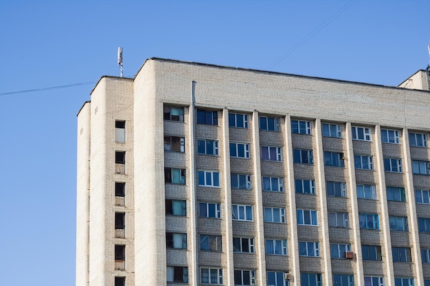 Windows of a tall house on a background of blue sky