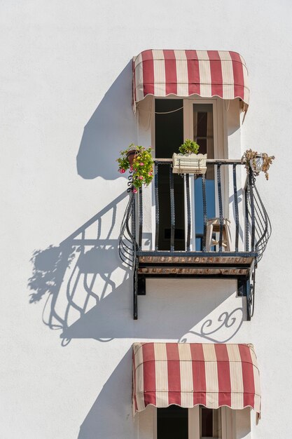 Windows with balcony on building facade with cast iron ornaments in Bodrum, Turkey