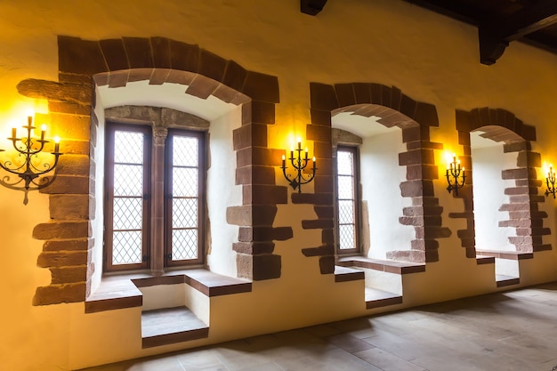 Windows with seating places in old castle, ancient stone building interior, Europe. Traditional european architecture, famous places for tourism and travel