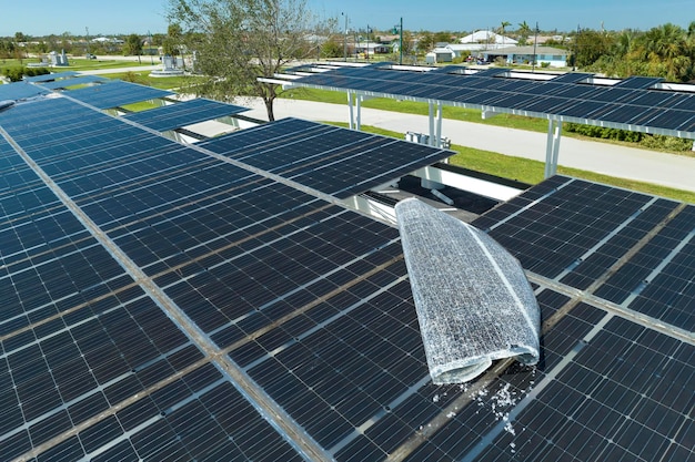 Windschade door orkaan aan zonnepanelen die zijn geïnstalleerd als schaduwdak over de parkeerplaats voor geparkeerde elektrische auto's Het falen van fotovoltaïsche technologie die is geïntegreerd in de stedelijke infrastructuur