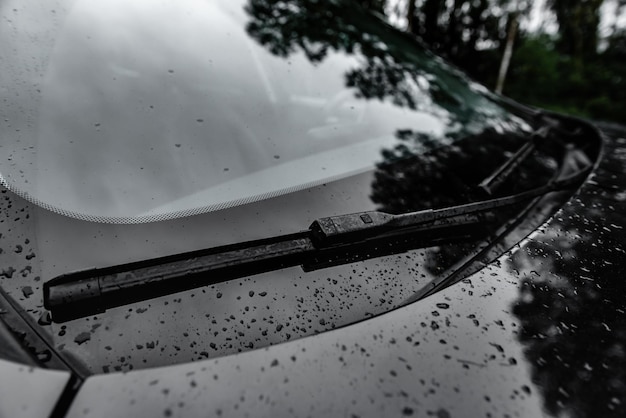 Photo windscreen wipes cleaning windshield glass on rainy day.