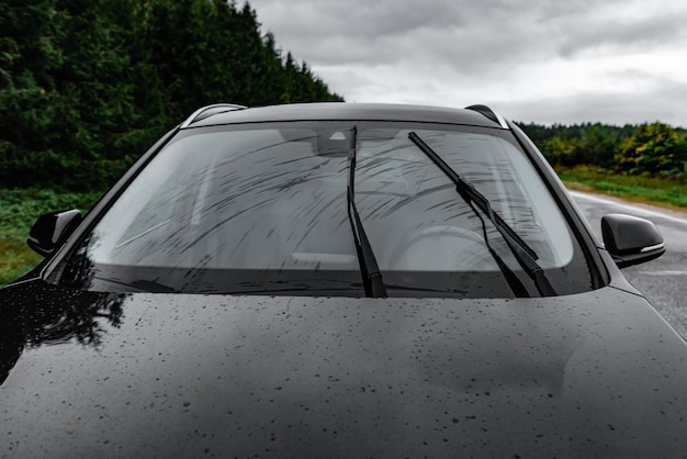 Photo windscreen wipes cleaning windshield glass on rainy day.