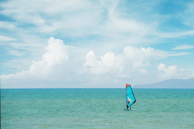 Windserfing man op een windserf zwemt langs de kust
