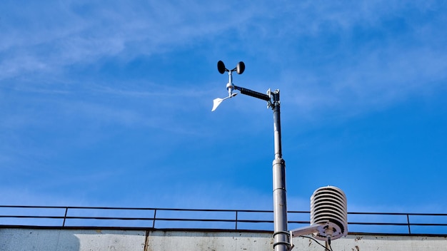 Windsnelheid anemometer windwijzer tegen de blauwe lucht met wolken op zonnige dag kopieerruimte