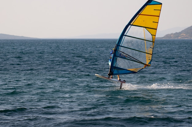 Windsurfen, extreme sporten. Watersport. Atleet in competitie. Zeegezicht met atleet. Hoge kwaliteit foto