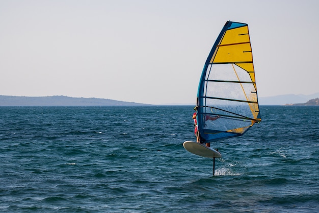 Windsurfing, extreme sports. Water sports. Athlete in competition. Seascape with athlete. High quality photo