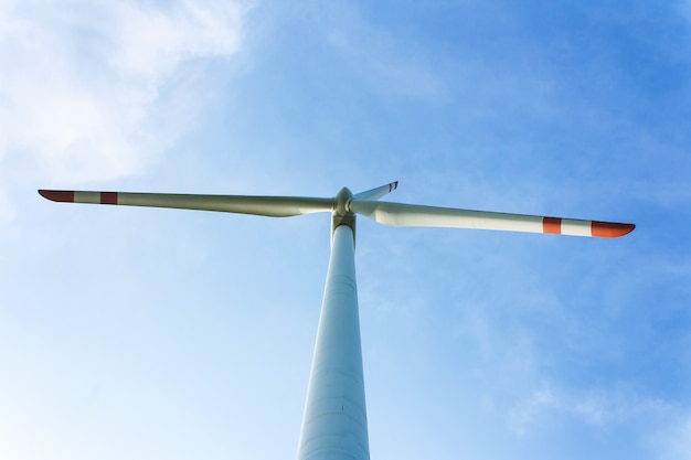 Windturbine die elektriciteit op blauwe hemel produceren