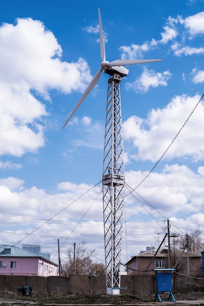 Windturbine in dorp tegen blauwe lucht met wolken Foto genomen in Rusland in de stad Orenburg