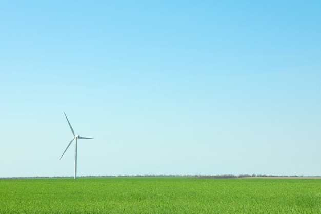 Windturbine in een groen grasveld, ruimte voor tekst. Prachtig lentegroen