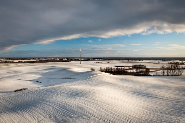 Windturbine op besneeuwd veld in de winter Alternatieve energie