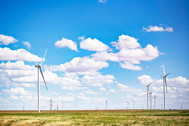 Foto windturbines in een veld met een blauwe lucht en wolken
