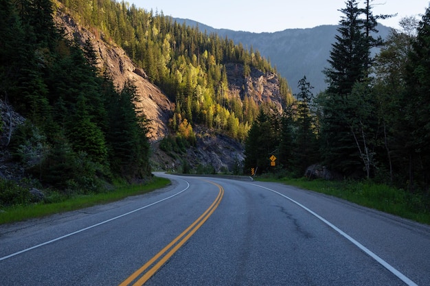 Windy scenic road around the mountains during a vibrant summer sunrise