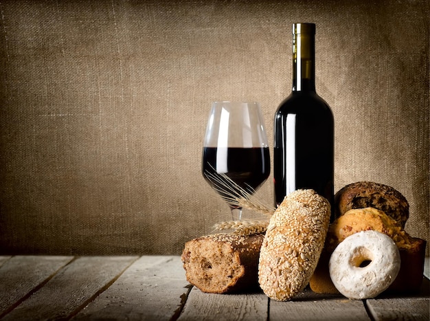 나무 테이블에 있는 와인과 다양한 빵