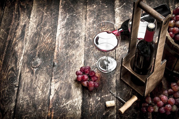 Sfondo di vino vino rosso con bicchieri di uva su uno sfondo di legno