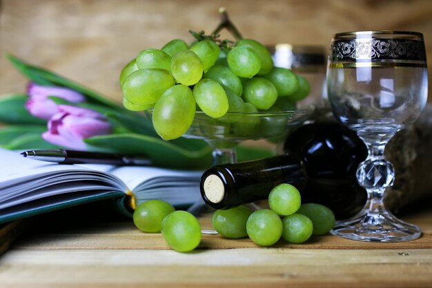 Foto libro bottiglia di vino e uva di vetro