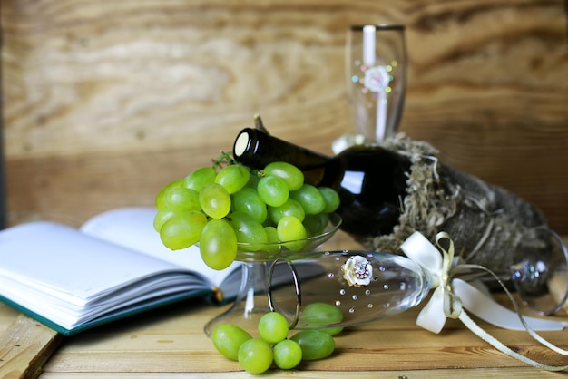 Foto libro bottiglia di vino e uva di vetro