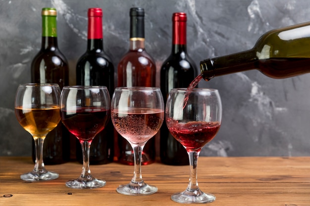 Una bottiglia di vino che riempie wineglass