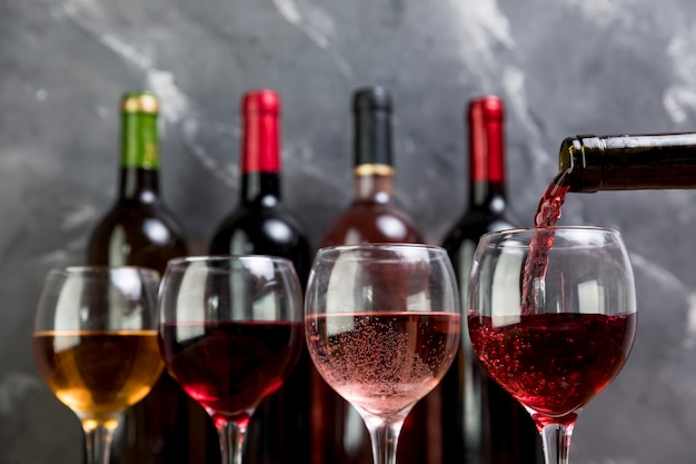 Una bottiglia di vino che riempie wineglass