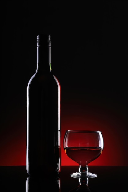 Wine bottle and glass on dark background